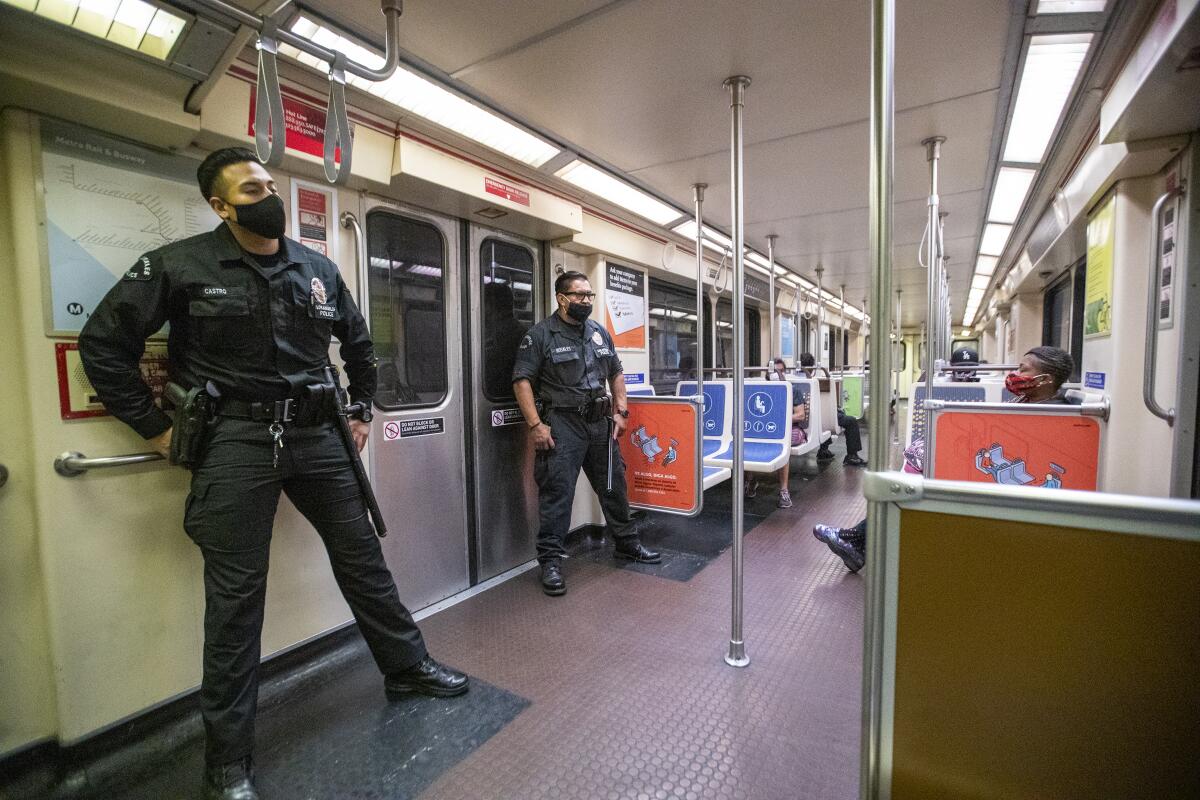 Two LAPD officers patrol a Metro Red Line subway car.