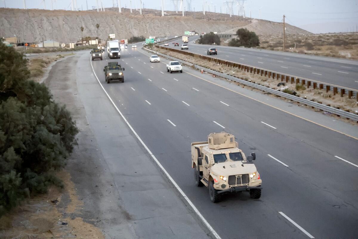 Military vehicles share a freeway with other vehicles