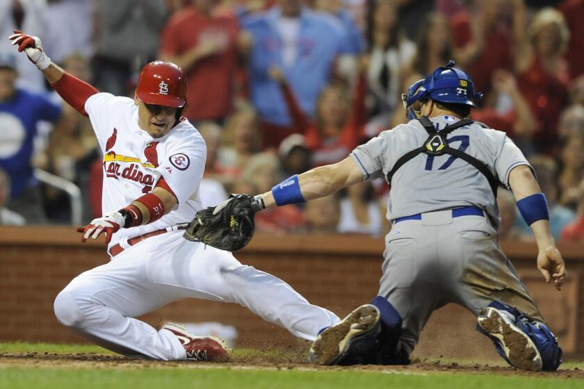 St. Louis Cardinals first baseman Craig Allen, left, is tagged out a home plate by Dodgers catcher A.J. Ellis during the fifth inning of the Dodgers' 3-2 win Monday.