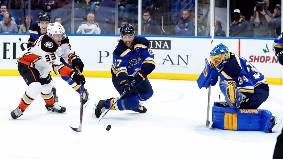 Ducks' Jakob Silfverberg and St. Louis Blues' Alex Pietrangelo, center, reach for a loose puck as Blues goalie Jake Allen, right, defends during the first period on Wednesday.