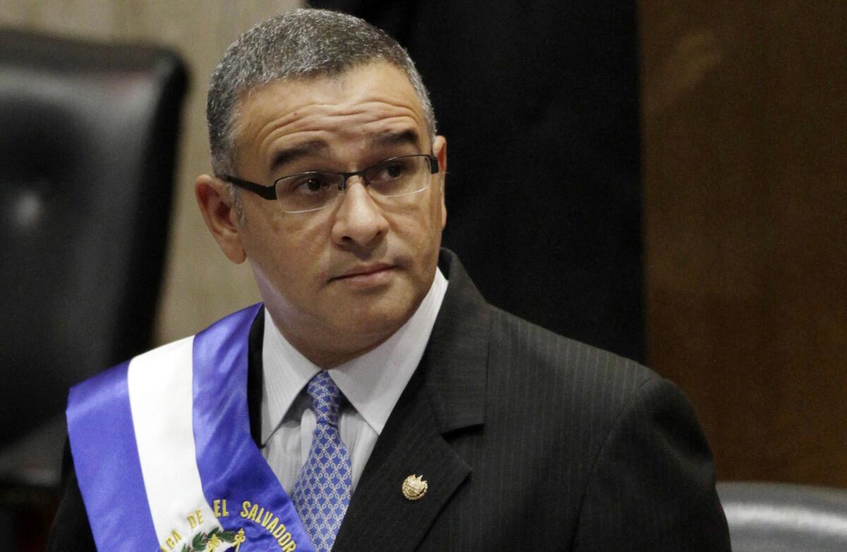 Mauricio Funes stands in the National Assembly while wearing a sash over his suit