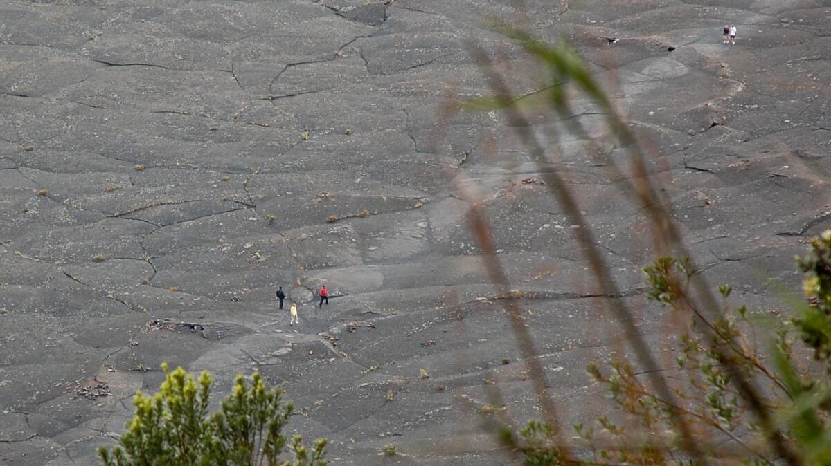 Tiny to the eye, these hikers are on the Kilauea Iki Trail, inside a caldera that's part of Hawaii Volcanoes National Park on the Big Island of Hawaii.