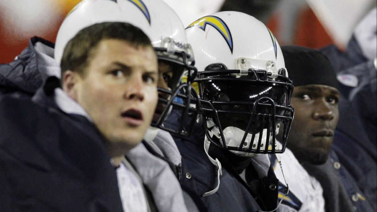 Chargers quarterback Philip Rivers, left, running back LaDainian Tomlinson, second from right, and fullback Andrew Pinnock sit on the bench during the third quarter of the AFC Championship football game against the New England Patriots on Jan. 20, 2008.