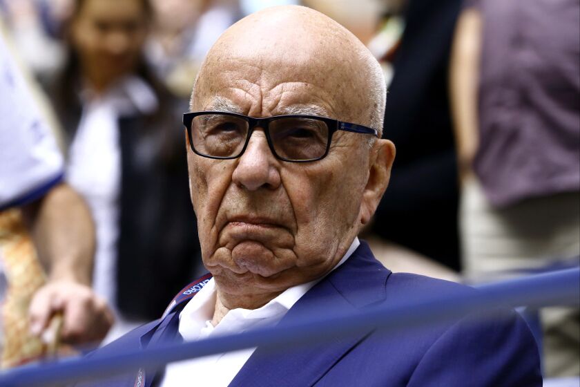 FILE- In this Sunday, Sept. 10, 2017 file photo, Rupert Murdoch waits for the start of the men's singles final of the U.S. Open tennis tournament in New York. Rupert Murdoch's British newspaper company has agreed to pay damages to a former intelligence officer whose computer was hacked by detectives working for Murdoch's now-defunct News of the World tabloid, lawyers said Friday, Oct. 6, 2017. (AP Photo/Julio Cortez, File)