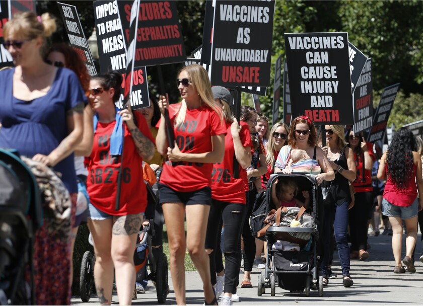 Demonstrators march around the state Capitol in protest of a measure to toughen rules for vaccination exemptions in August.