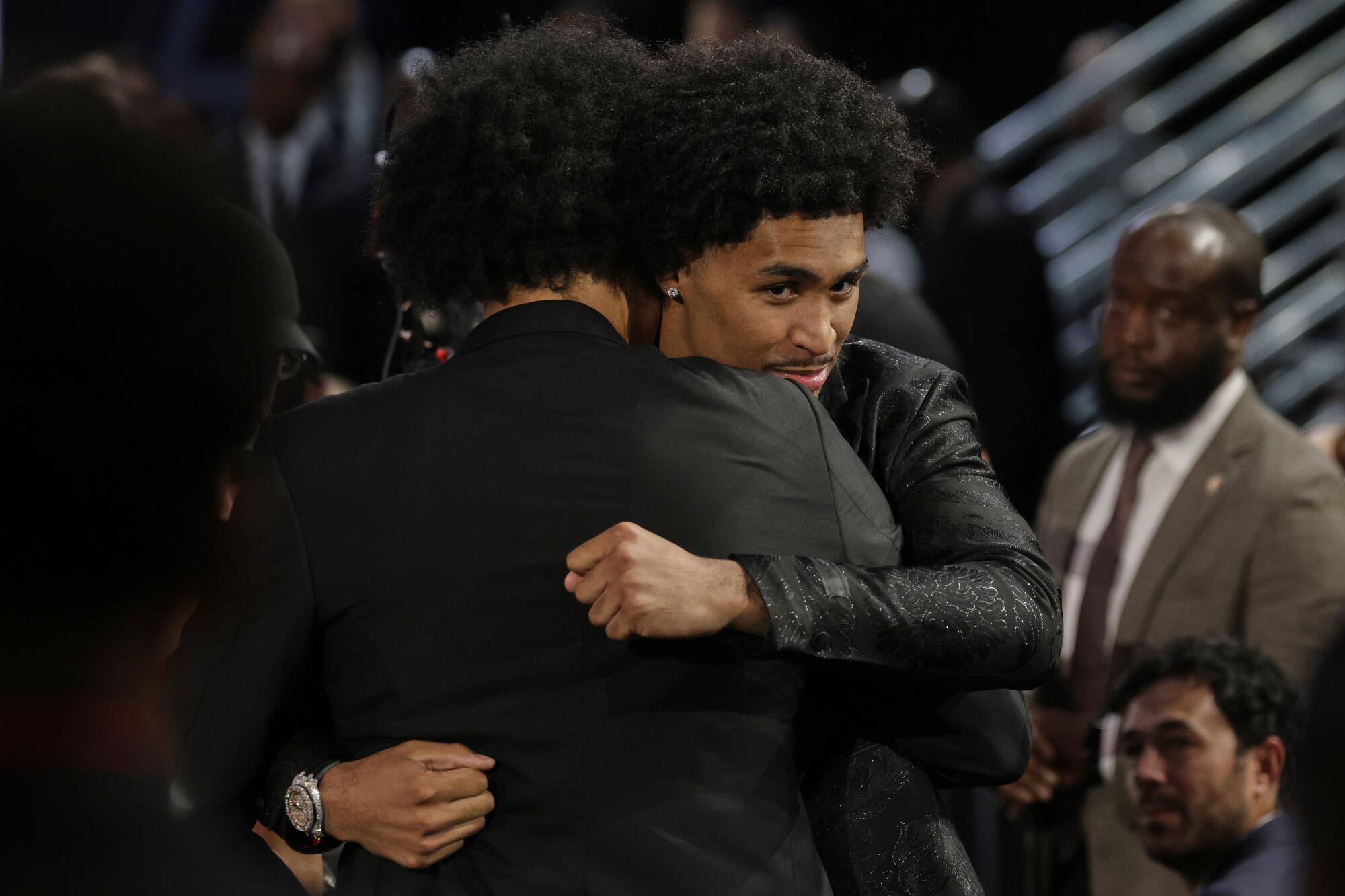 Dylan Harper hugs a person wearing a dark jacket