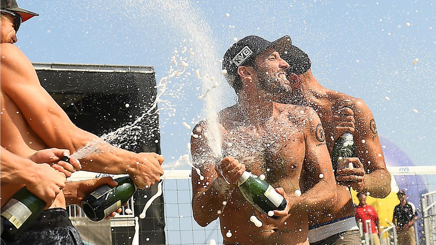 LONG BEACH-CA-JULY 16, 2017: Nick Lucena and Phil Dalhausser, center, are sprayed with champagne after winning 1st place in the World Series of Beach Volleyball in Long Beach on Sunday. (Christina House / For The Times)