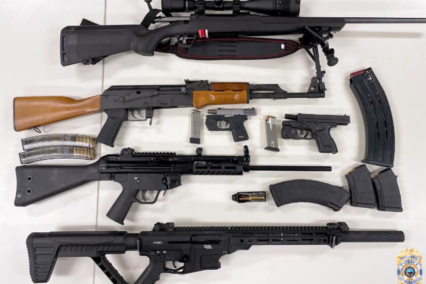 A top-down view of two rifles, two automatic rifles and two pistols, and extra magazines. 