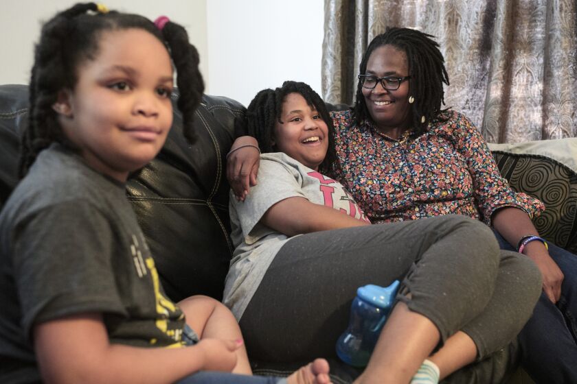 FILE - Deleah Payne, 12, center, spends time with her mother Delisa, right, and 6-year-old sister Delynn, left, as they watch movie clips on their living room television in Evansville, Ind., Tuesday evening, Aug. 27, 2019. Deleah and Delynn were both diagnosed with autism. For the first time, autism is being diagnosed more frequently in Black and Hispanic children than in white kids in the U.S., the Centers for Disease Control and Prevention said Thursday, March 23, 2023. (Sam Owens/Evansville Courier & Press via AP, File)