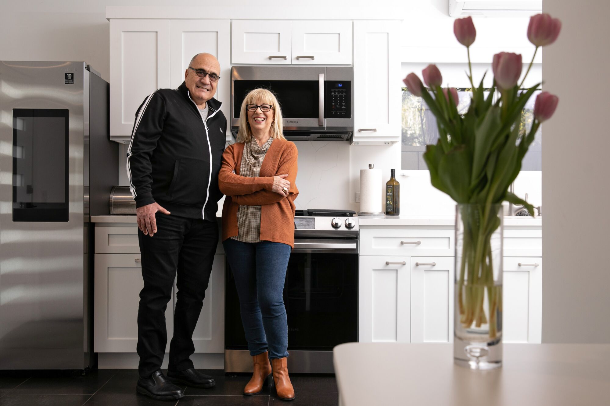 A man and a woman standing in a kitchen 