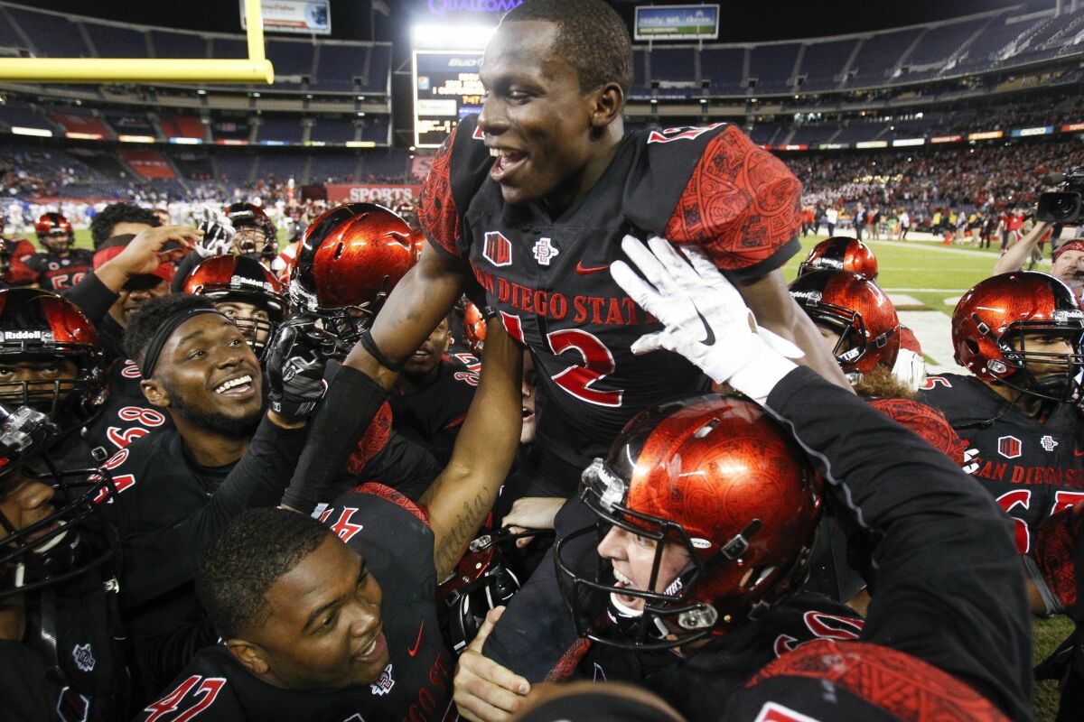 The Aztecs' Malik Smith is raised up by teammates as the Aztecs celebrate their 27-24 win over Air Force to win the Mountain West conference championship at Qualcomm Stadium.