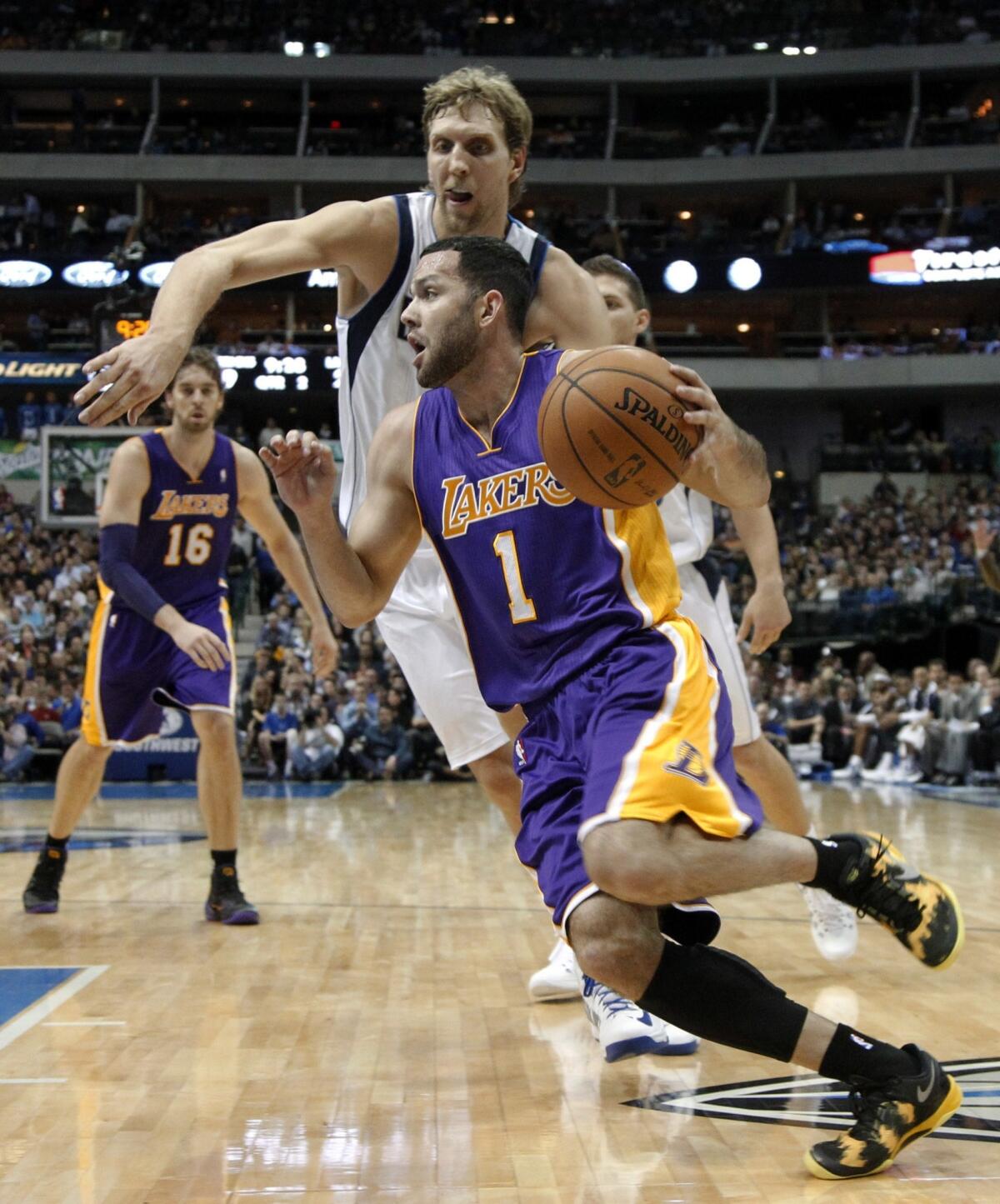 Lakers guard Jordan Farmar, front, tries to drive past Dallas Mavericks center Dirk Nowitzki during the first half of Tuesday's game.