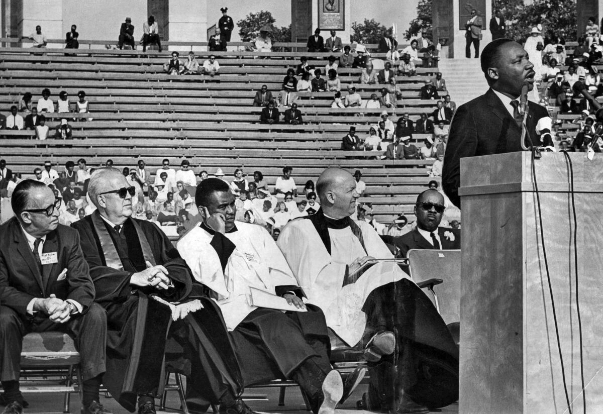 May 31, 1964: King speaks at a civil rights rally at L.A. Memorial Coliseum. Listening from left are entertainer Walter O'Keefe, the Rev. Bryon C. Cole, the Rev. Joseph Francis and the Rev. John H. Burt.