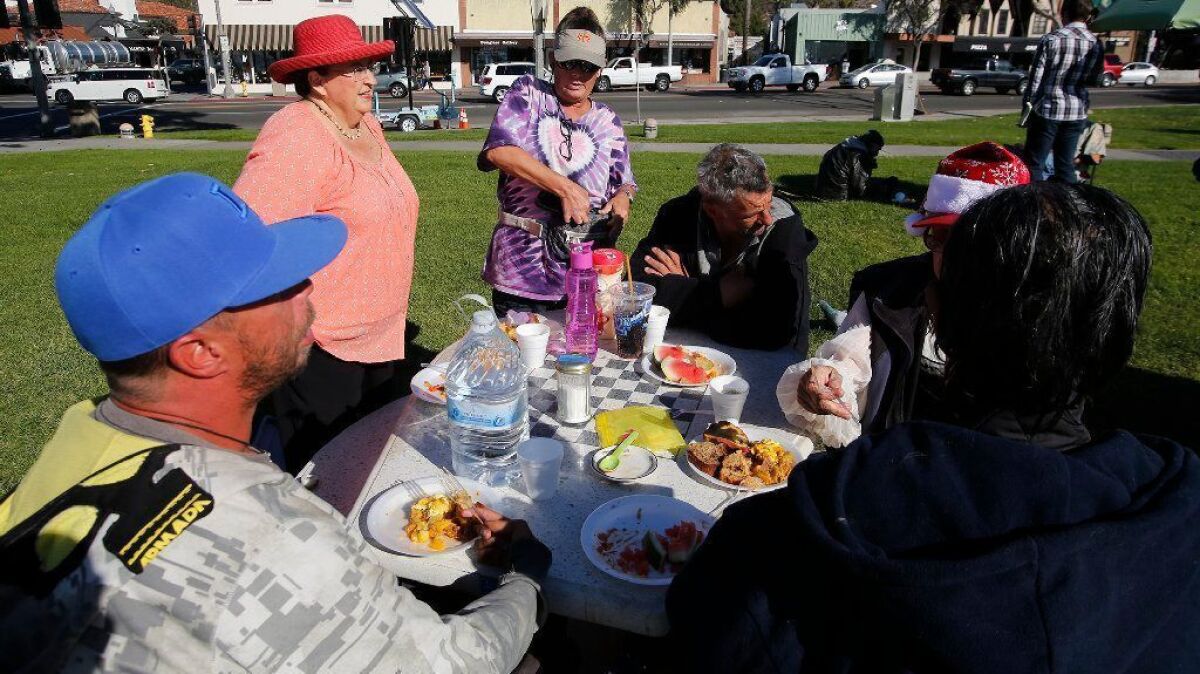 Trish Miller serves a homeless outreach breakfast at Main Beach in Laguna Beach on Dec. 13.