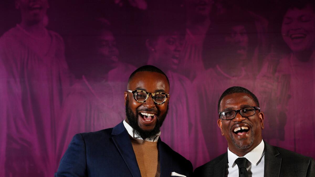 A joyful curator Tyree Boyd-Pates, left, and historian Daniel Walker (co-curators) gather at the "How Sweet the Sound: Gospel Music in Los Angeles" exhibit at the California African American Museum in Los Angeles.