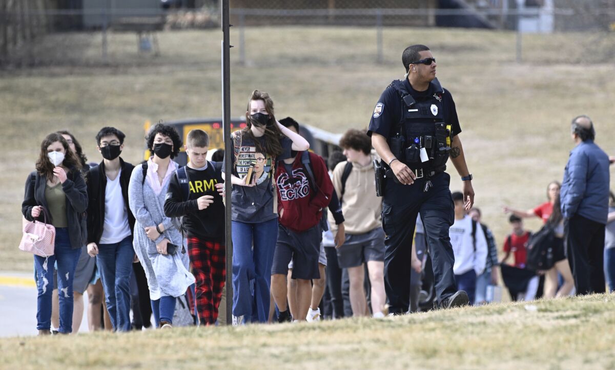 Students from Olathe East High school are led off busses to reunite with their parents Friday, March 4, 2022, at Pioneer Trail Middle School in Olathe, Kan.,, after a shooting at the high school. Authorities say a suspect shot and wounded a school resource officer and an administrator at the suburban Kansas City high school. Police say a suspect has been taken into custody and there are no reports of injured students. (Reed Hoffmann/The Kansas City Star via AP)