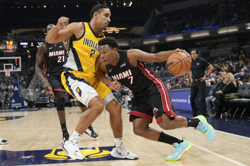 Miami Heat guard Kyle Lowry, right, drives around Indiana Pacers guard Malcolm Brogdon during the first half of an NBA basketball game in Indianapolis, Friday, Dec. 3, 2021. (AP Photo/AJ Mast)