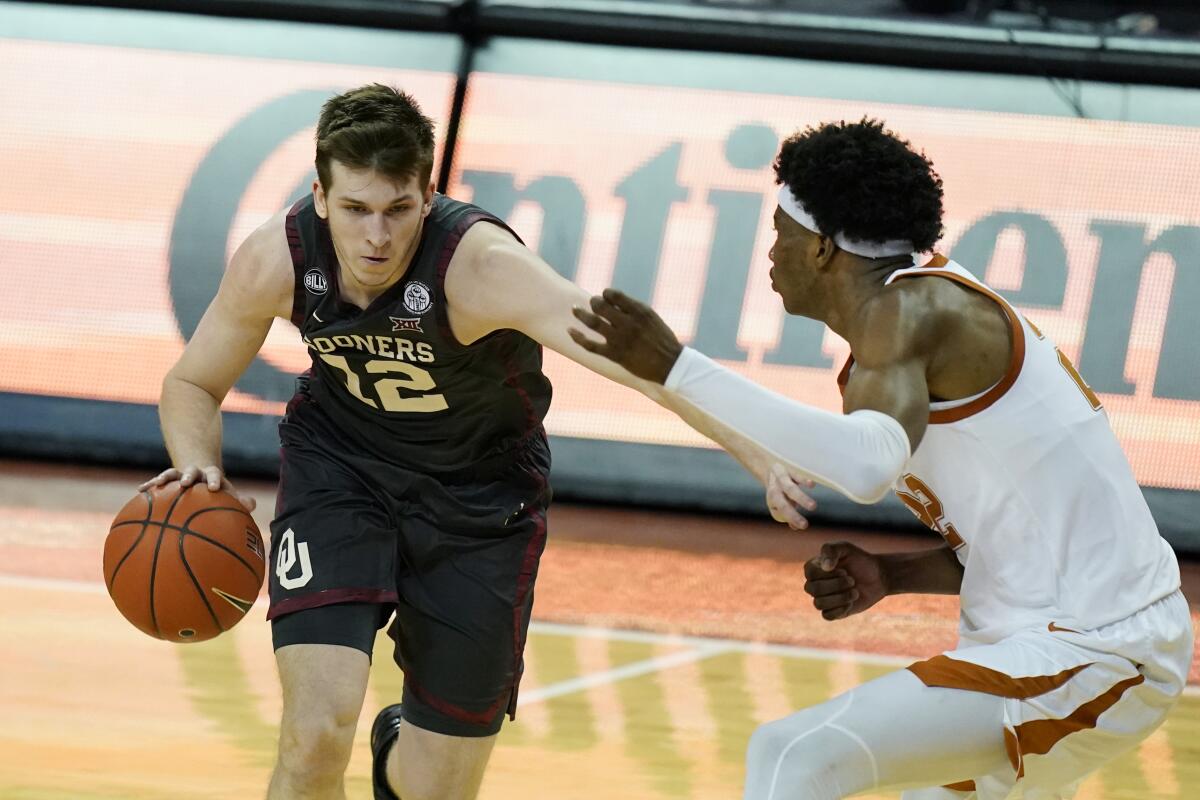 Oklahoma guard Austin Reaves drives against Texas forward Kai Jones.