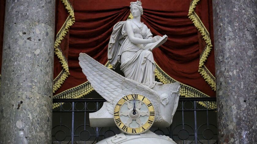 The clock in the National Statuary Hall shows midnight at the U.S. Capitol, marking the time another government shutdown began.