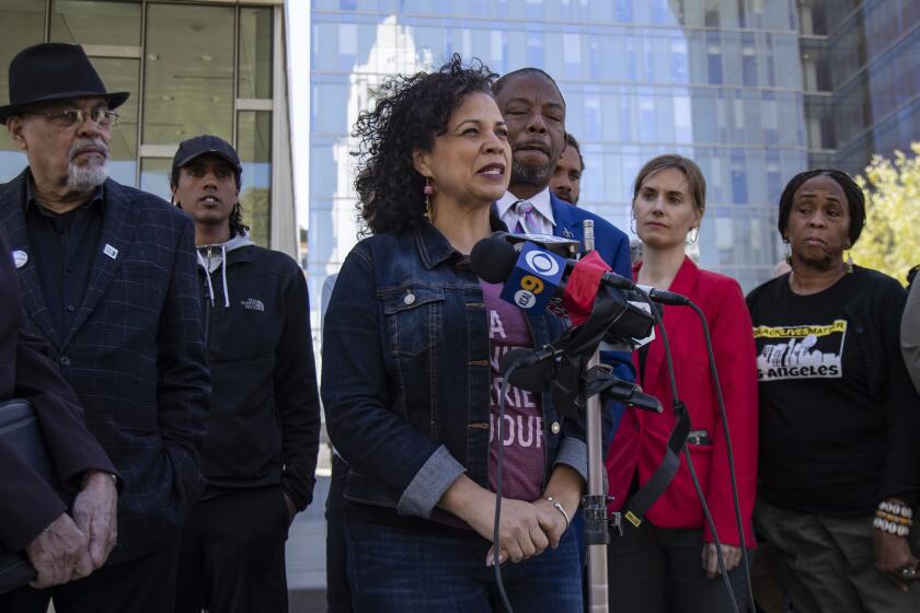 LOS ANGELES, CA - FEBRUARY 11, 2020: Professor Melina Abdullah, a Black Lives Matter leader, announces the filing of a federal lawsuit against the Los Angeles Police Department on February 11, 2020 in Los Angeles, California. Attorney Carl Douglas, back, right, alleges that Abdullah was "falsely, wrongfully and intentionally detained, imprisoned and arrested" during a commission meeting. (Gina Ferazzi/Los AngelesTimes)