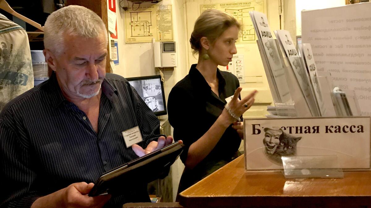 Yevgeny Markov looks through his iPad for photos of Begemot the cat, with whom he's worked for nearly 12 years as a night guard at the Bulgakov museum in Moscow.