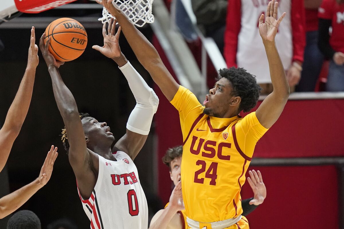 Utah center Lahat Thioune, left, shoots in front of USC forward Joshua Morgan during the first half Saturday.
