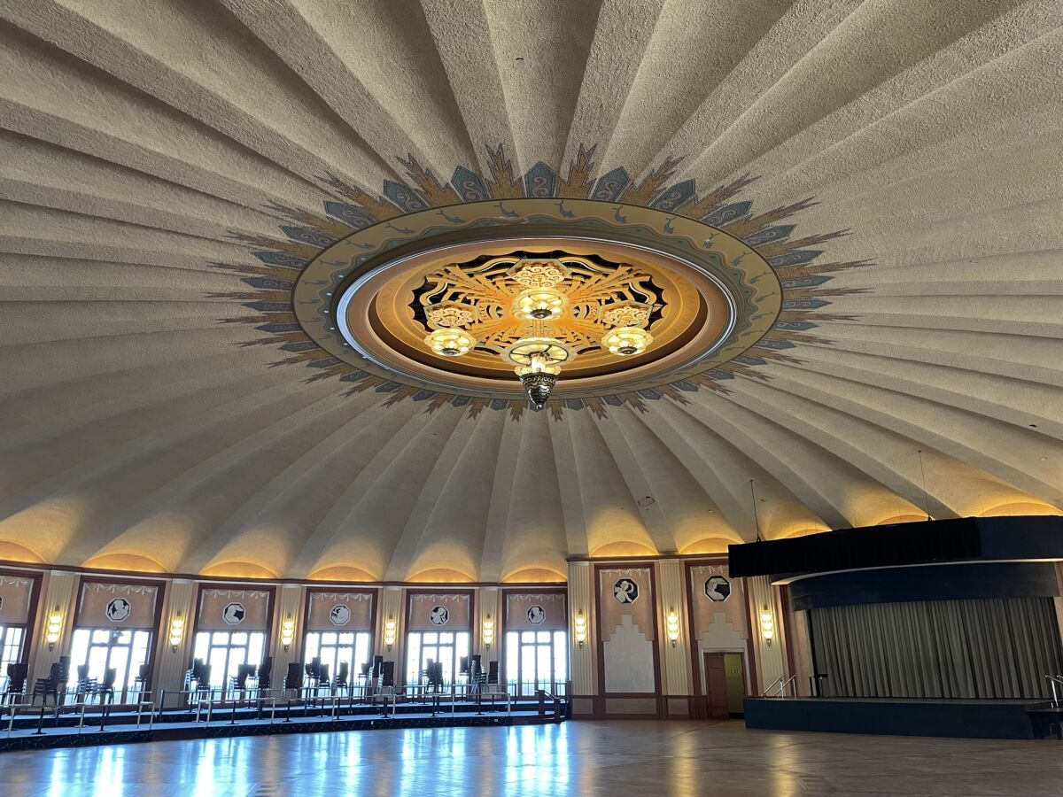 A dance hall with a large light fixture on the ceiling and Art Deco style.