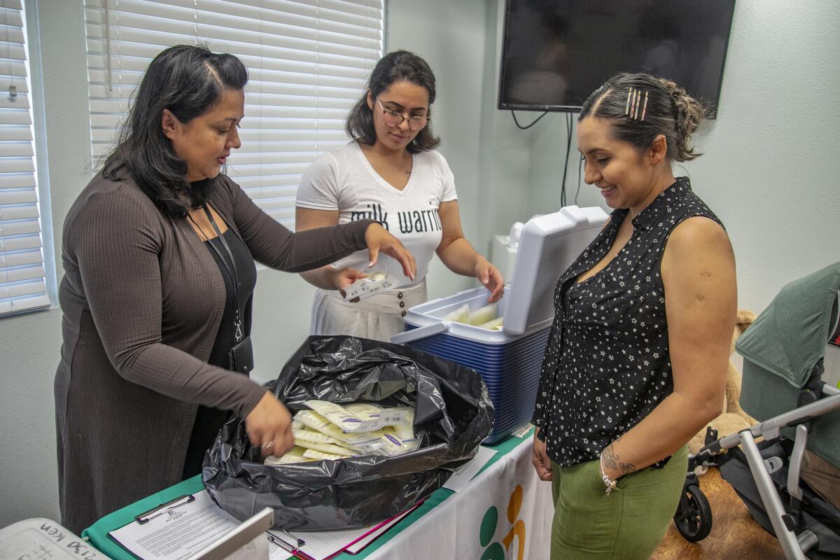 Marketing Manager Angelica Rosa and Jasmine Rivera of Mothers' Milk Bank pack up containers of mother's milk.