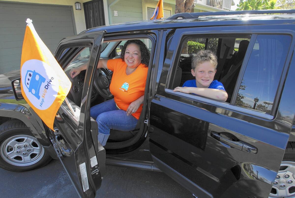 Costa Mesa resident Leah Fountain, left, is a new CareDriver with HopSkipDrive, a transportation service geared for children that officially launches in Orange County in April. In the backseat is Cooper Dwight, 12.