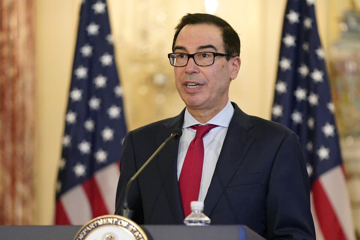 Steven T. Mnuchin speaking from a lectern in front of two American flags