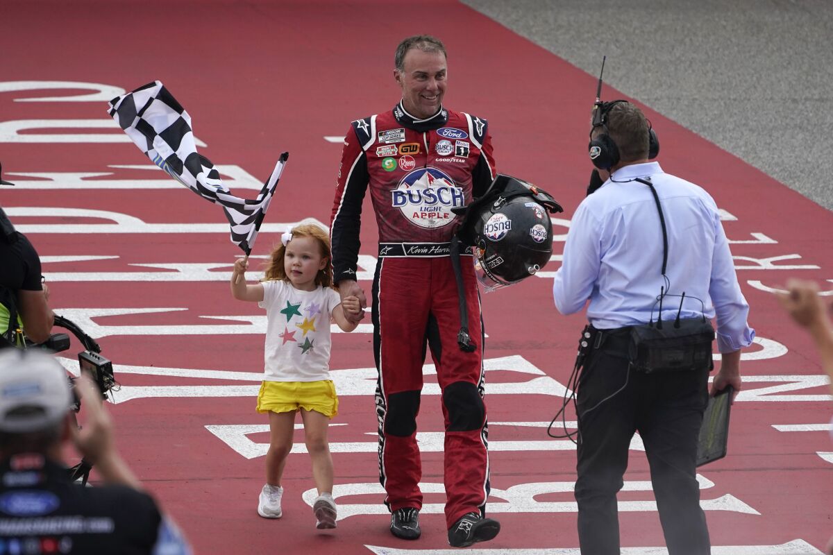 Kevin Harvick celebrates with his daughter Piper after winning the NASCAR Cup Series auto race at the Michigan International Speedway in Brooklyn, Mich., Sunday, Aug. 7, 2022. (AP Photo/Paul Sancya)