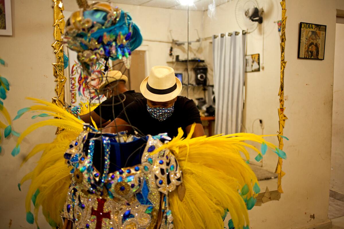 Leandro dos Santos adjusts a costume from last year's Carnival in Rio's Vila Isabel district.