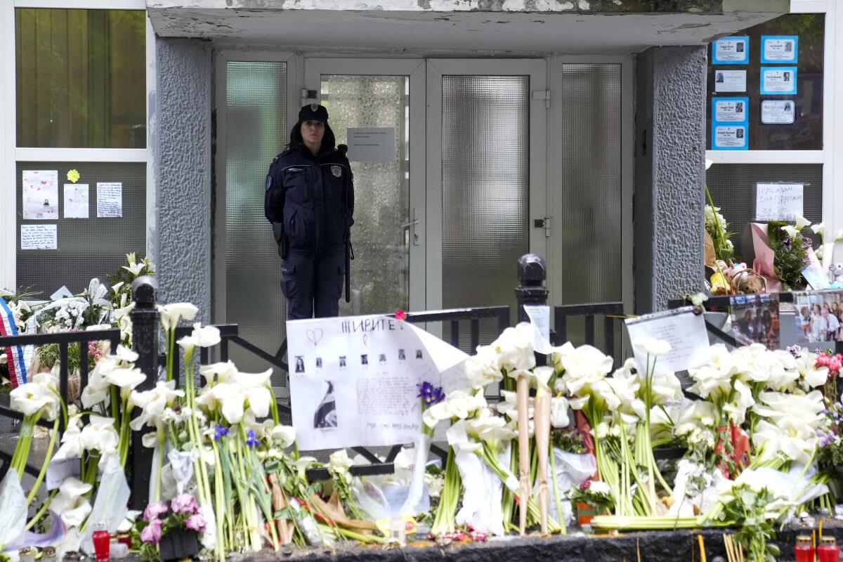 Floral tributes at a school in Serbia where mass shooting took place