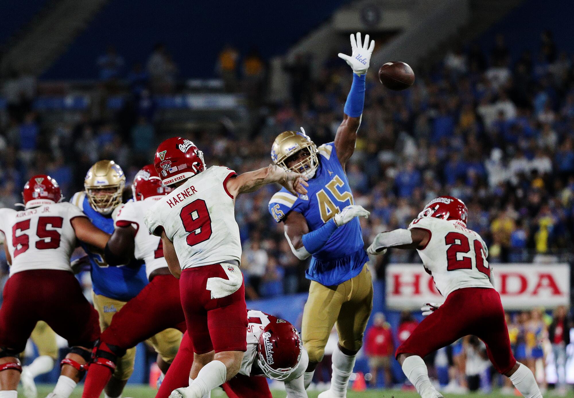 UCLA linebacker Mitchell Agude (45) tries to deflect a pass from Fresno State quarterback Jake Haener 