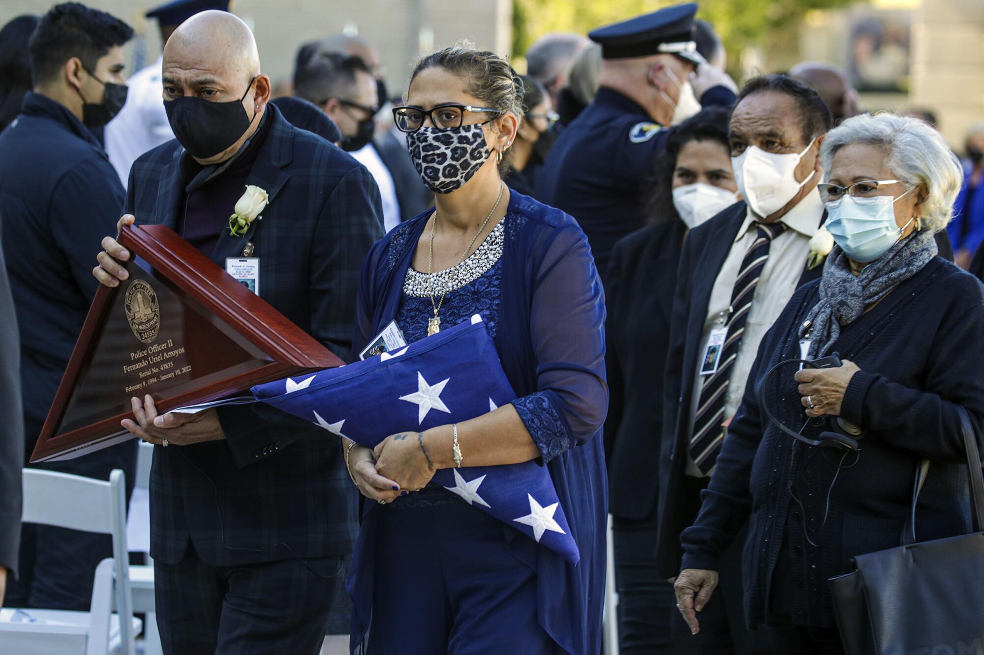 Karina Membreno, the mother of fallen LAPD Officer Fernando Arroyos, holds the flag given to her by LAPD Chief Michel Moore.
