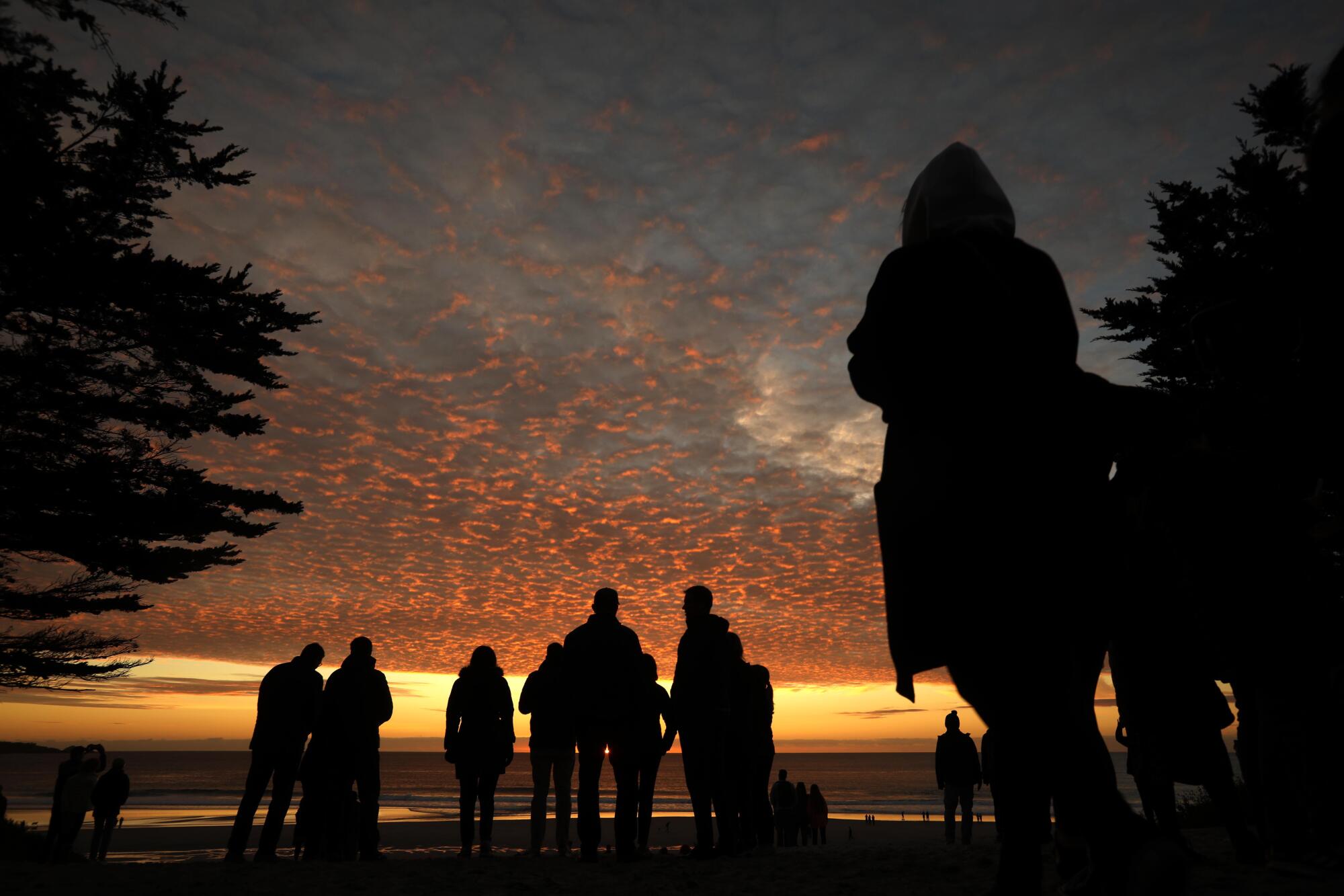 People watch the sunset where Ocean Avenue meets the Pacific Ocean in Carmel-by-the-Sea.