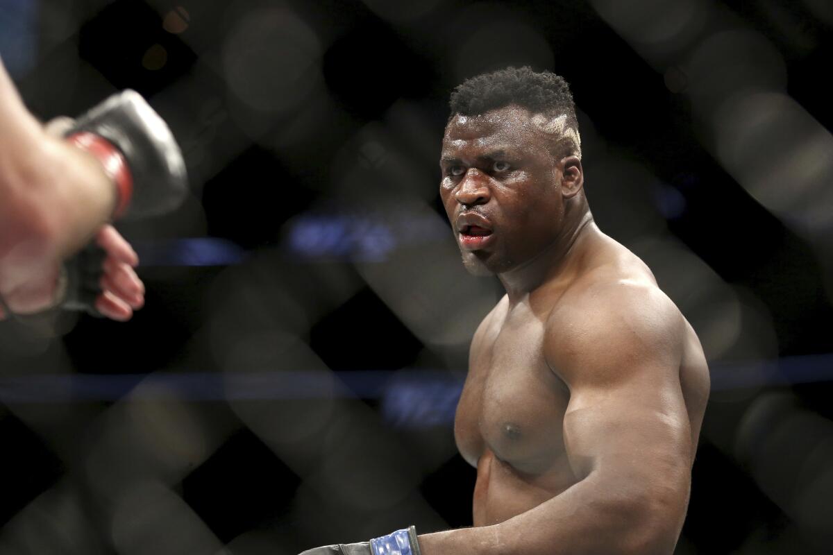 Francis Ngannou stares at Stipe Miocic during a heavyweight championship bout at UFC 220