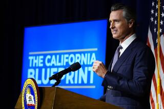 California Gov. Gavin Newsom unveils the revised budget plan during a news conference in Sacramento.
