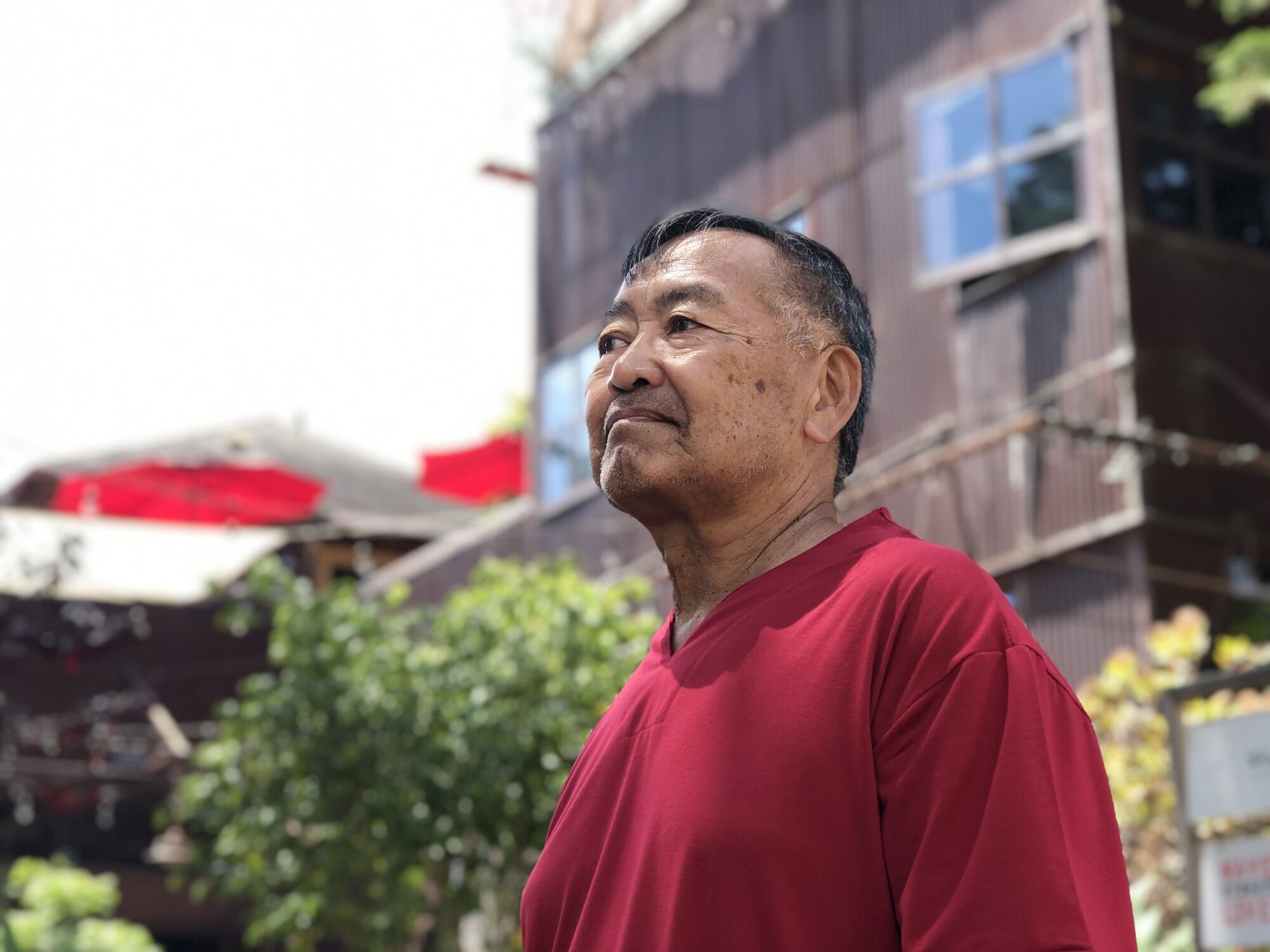 A man pictured from the chest up, standing outside an older home.