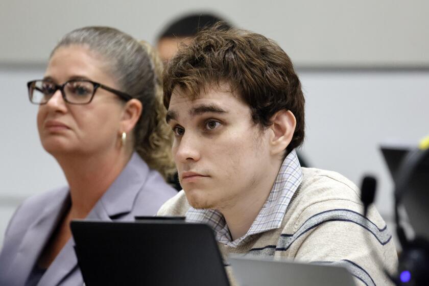Marjory Stoneman Douglas High School shooter Nikolas Cruz looks up at his attorney, Assistant Public Defender Melisa McNeill, as she gives her closing argument in the penalty phase of Cruz's trial at the Broward County Courthouse in Fort Lauderdale, Fla. on Tuesday, Oct. 11, 2022. Cruz previously plead guilty to all 17 counts of premeditated murder and 17 counts of attempted murder in the 2018 shootings. (Amy Beth Bennett/South Florida Sun Sentinel via AP, Pool)