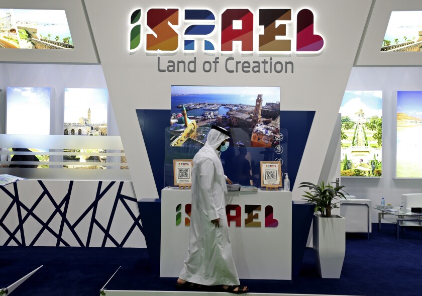 A man passes by the Israel stand on the opening day of the Arabian Travel Market exhibition, in Dubai, United Arab Emirates, Sunday, May 16, 2021. As violence flares within Israel and on a day in which Israeli airstrikes on Gaza City killed at least 42 people Sunday, it was business as usual for a senior Israeli tourism official in Dubai as she promoted the country as a must-see destination for Muslim visitors. (AP Photo/Kamran Jebreili)