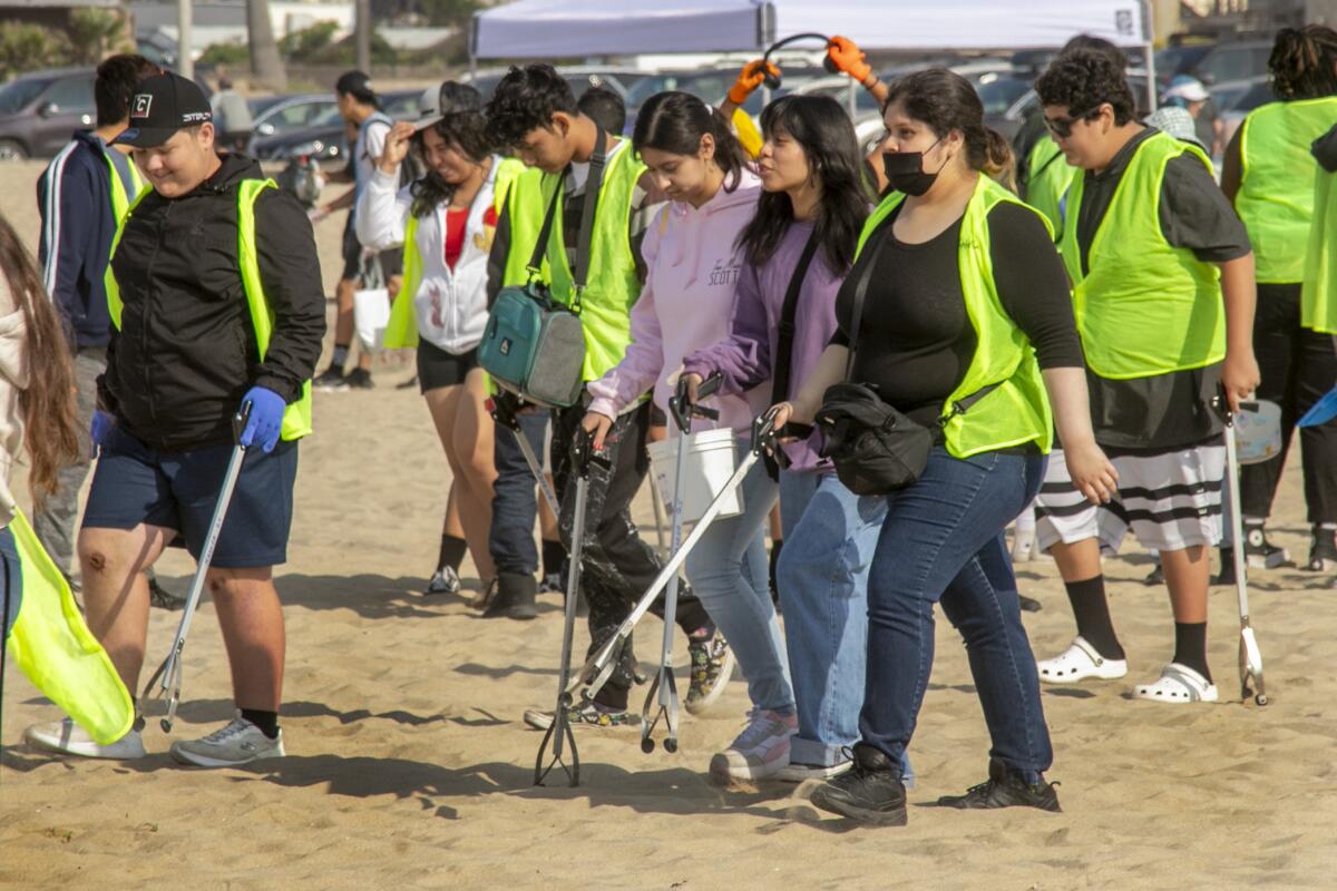 Katella High School students start their search for trash at Huntington State Beach Saturday.
