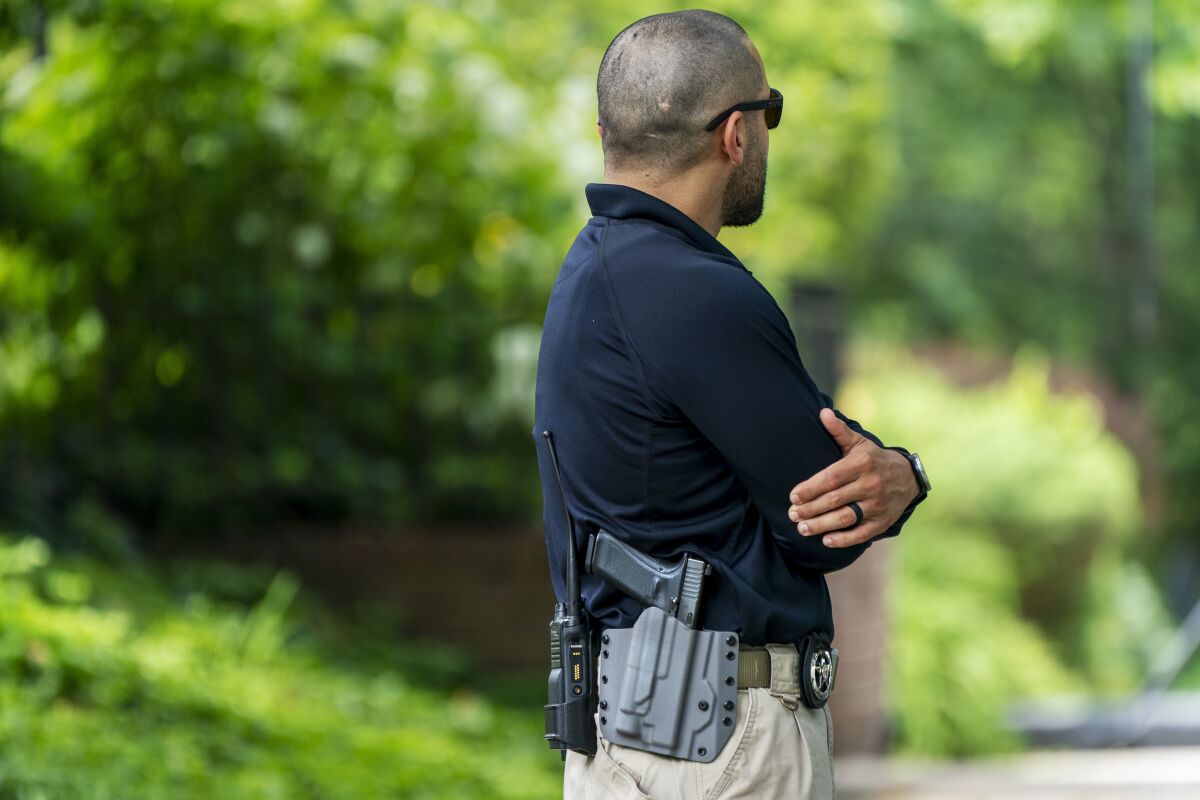 FILE - A U.S. Marshal patrols outside the home of Supreme Court Justice Brett Kavanaugh, in Chevy Chase, Md., June 8, 2022. The House has given final approval to legislation to allow around-the-clock security protection for families of Supreme Court justices. The vote on Tuesday came one week after a man carrying a gun, knife and zip ties was arrested near Justice Brett Kavanaugh’s house after threatening to kill the justice. (AP Photo/Jacquelyn Martin, File)