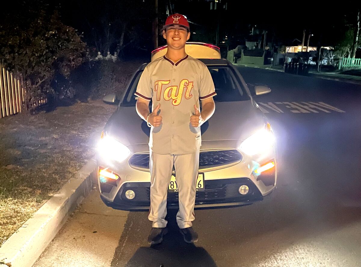 Aiden Preuss stands in front of his 2021 Kia Forte after a night baseball game.