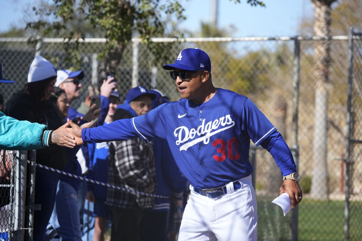 Dodgers manager Dave Roberts shakes hands with fans during the first day of spring training.