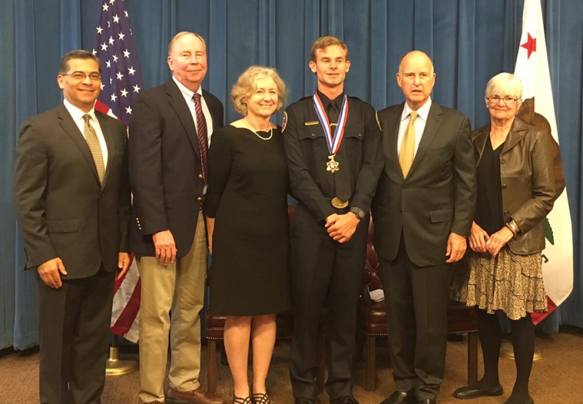 Medal of Valor recipient David Wilson stands with his parents, a family friend, Gov. Jerry Brown and Atty. Gen. Xavier Becerra.