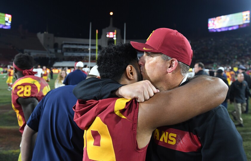 Coach Clay Helton kisses running back Vavae Malepeai after USC's 24-17 loss to Notre Dame on Saturday at the Coliseum.