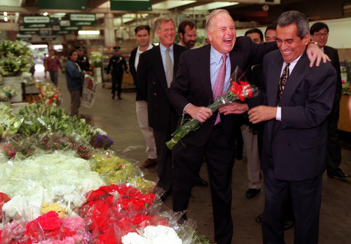 Mayor Richard Riordan, with bouquet in hand, jokes with City Councilman Richard Alatorre.