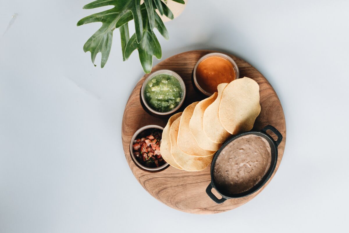 An overhead photo of a platter of tortillas, beans and salsas from Alma Cocina de Mexico.