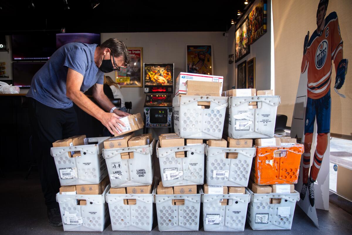 Mike Jaspersen, co-founder of Jaspy's Case Breaks, prepares boxes of sports cards for shipment to customers.